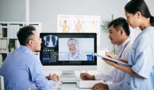 A group of doctors looking at a computer screen.