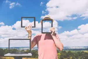 A person holding up three frames in front of their face.